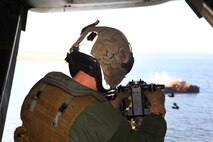 Staff Sgt. Rodney McDowall, Marine Medium Tiltrotor Squadron 266 MV-22B Osprey crew chief, fires the GAU-16 .50-caliber heavy-machine gun at a target from the ramp of the Osprey while conducting a live-fire gun shoot, Nov. 28.