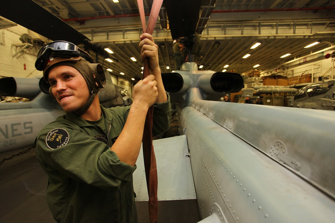 Sgt. Matthew Yoskovich, a Greensboro, Penn., native and AH-1W Super Cobra crew chief with Marine Medium Tiltrotor Squadron 261 (Reinforced), 24th Marine Expeditionary Unit, oversees maintenance of a main rotor to an AH-1W Super Cobra aboard USS Iwo Jima, Dec. 3, 2012. The 24th MEU is deployed with the Iwo Jima Amphibious Ready Group and is currently in the 6th Fleet area of responsibility. Since deploying in March, they have supported a variety of missions in the U.S. Central, Africa and European Commands, assisted the Navy in safeguarding sea lanes, and conducted various bilateral and unilateral training events in several countries in the Middle East and Africa. The Cobras, along with UH-1N Hueys, make up the "Skid" detachment for VMM-261 (Rein) and are originally from Marine Light Attack Helicopter Squadron 269, based at Marine Corps Air Station New River, N.C. (U.S. Marine Corps photo by Lance Cpl. Tucker S. Wolf/Released)