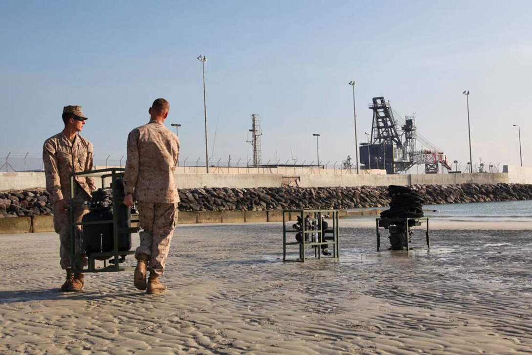 Marines assigned to Combat Logistics Battalion 15, 15th Marine Expeditionary Unit, carry a component of the Light-Weight Water Purification System to function-test the equipment at Camp Patriot, Kuwait, Nov. 28. The Marines recently completed Eager Mace 13, a routine training exercise that focused on promoting regional security, stability and mutual interests in the region. The 15th MEU is deployed as part of the Peleliu Amphibious Ready Group as a U.S. Central Command theater reserve force, providing support for maritime security operations and theater security cooperation efforts in the U.S. 5th Fleet area of responsibility. (U.S. Marine Corps photo by Cpl. Timothy R. Childers)