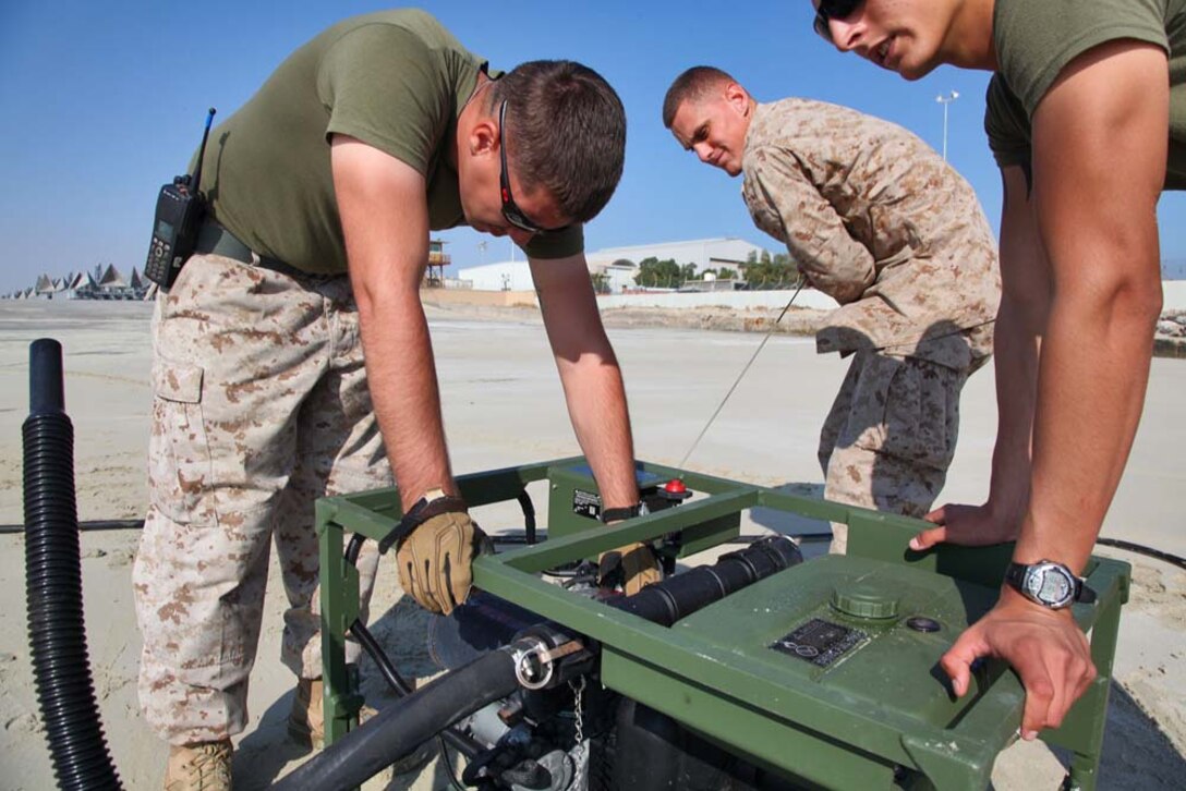 Corporal Daniel Dickson (center), water support technician, Engineer Detachment, Combat Logistics Battalion 15, 15th Marine Expeditionary  Unit, starts the fuel-pump of a Light-Weight Water Purification System to function-test the equipment at Camp Patriot, Kuwait, Nov. 28. The Marines recently completed Eager Mace 13, a routine training exercise that focused on promoting regional security, stability and mutual interests in the region. The 15th MEU is deployed as part of the Peleliu Amphibious Ready Group as a U.S. Central Command theater reserve force, providing support for maritime security operations and theater security cooperation efforts in the U.S. 5th Fleet area of responsibility. Dickson, 20, is from Antioch, Calif. (U.S. Marine Corps photo by Cpl. Timothy R. Childers)