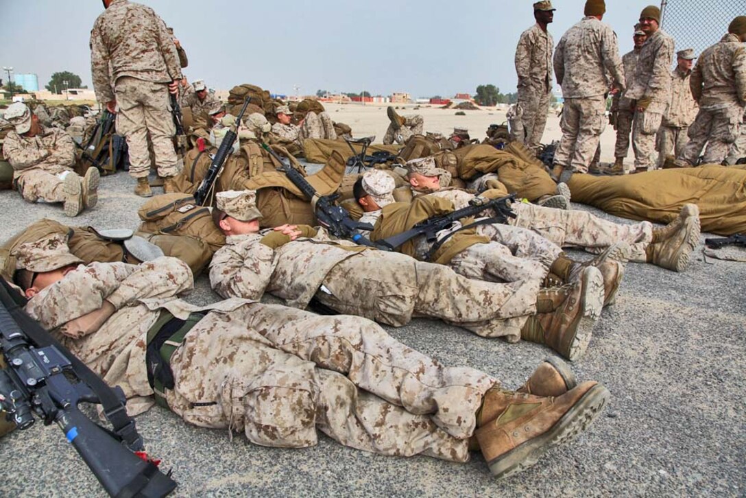 Marines assigned to the 15th Marine Expeditionary Unit catch some rest as they wait for a Landing Craft Air Cushion to transport them and their cargo from Camp Patriot, Kuwait, to the USS Rushmore on Nov. 29. The Marines recently completed Eager Mace 13, a routine training exercise that focused on promoting regional security, stability and mutual interests in the region. The 15th MEU is deployed as part of the Peleliu Amphibious Ready Group as a U.S. Central Command theater reserve force, providing support for maritime security operations and theater security cooperation efforts in the U.S. 5th Fleet area of responsibility. (U.S. Marine Corps photo by Cpl. Timothy R. Childers)