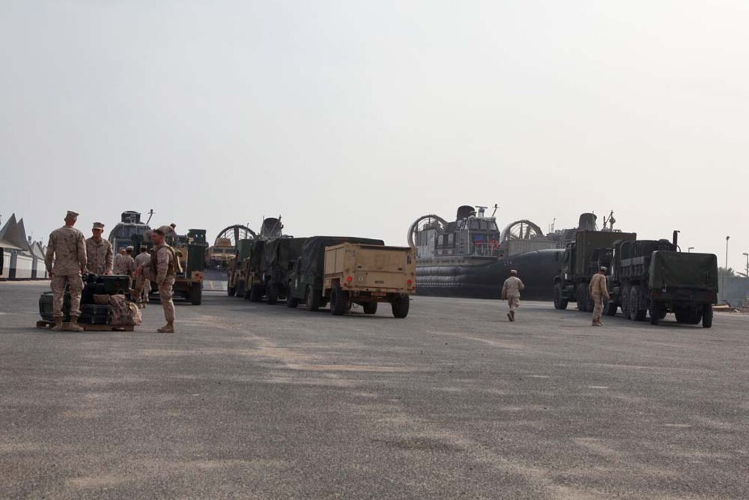 Marines assigned to the 15th Marine Expeditionary Unit, stage their vehicles, preparing them to load onto a Landing Craft Air Cushion for transport from Camp Patriot, Kuwait, to the USS Rushmore on Nov. 29. The Marines recently completed Eager Mace 13, a routine training exercise that focused on promoting regional security, stability and mutual interests in the region. The 15th MEU is deployed as part of the Peleliu Amphibious Ready Group as a U.S. Central Command theater reserve force, providing support for maritime security operations and theater security cooperation efforts in the U.S. 5th Fleet area of responsibility. (U.S. Marine Corps photo by Cpl. Timothy R. Childers)