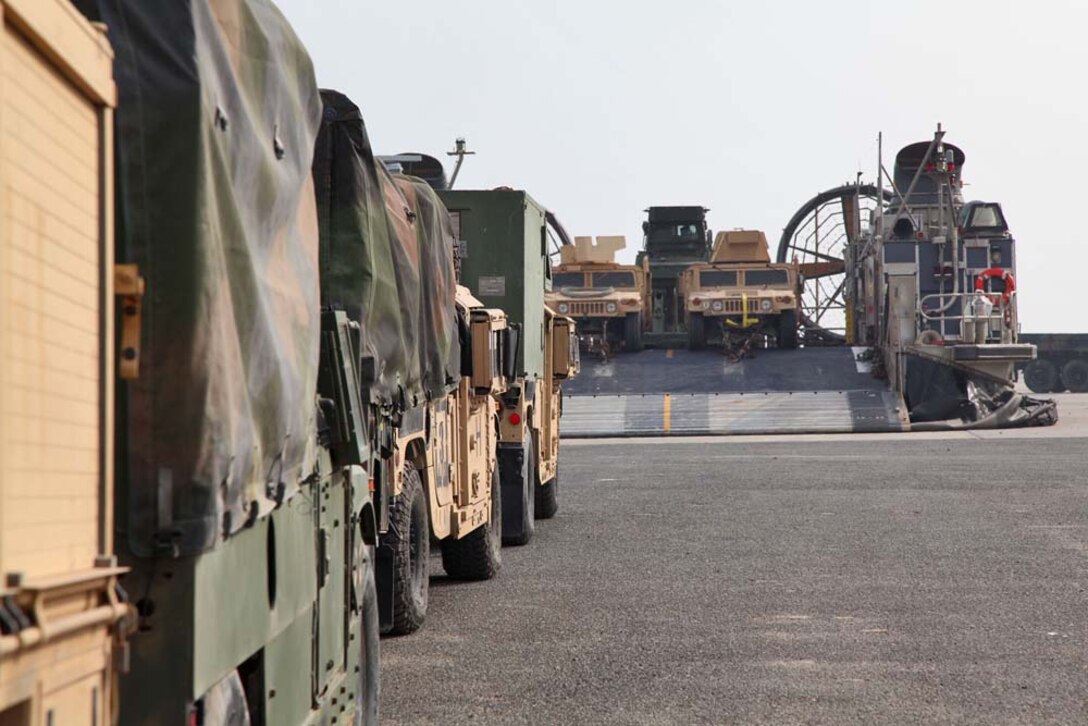 Marines assigned to the 15th Marine Expeditionary Unit, stage their vehicles, preparing them to load onto a Landing Craft Air Cushion for transport from Camp Patriot, Kuwait, to the USS Rushmore on Nov. 29. The Marines recently completed Eager Mace 13, a routine training exercise that focused on promoting regional security, stability and mutual interests in the region. The 15th MEU is deployed as part of the Peleliu Amphibious Ready Group as a U.S. Central Command theater reserve force, providing support for maritime security operations and theater security cooperation efforts in the U.S. 5th Fleet area of responsibility. (U.S. Marine Corps photo by Cpl. Timothy R. Childers)