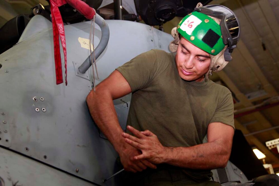Corporal Oscar J. Urquilla, avionics technician, Marine Medium Helicopter Squadron 364 (Rein.), 15th Marine Expeditionary Unit, performs routine maintenance on an AH-1Z Super Cobra in the hangar bay of the USS Peleliu, Nov. 29. The 15th MEU is deployed as part of the Peleliu Amphibious Ready Group as a U.S. Central Command theater reserve force, providing support for maritime security operations and theater security cooperation efforts in the U.S. 5th Fleet area of responsibility. Urquilla, 22, is from Boise, Idaho. (U.S. Marine Corps photo by Cpl. John Robbart III)