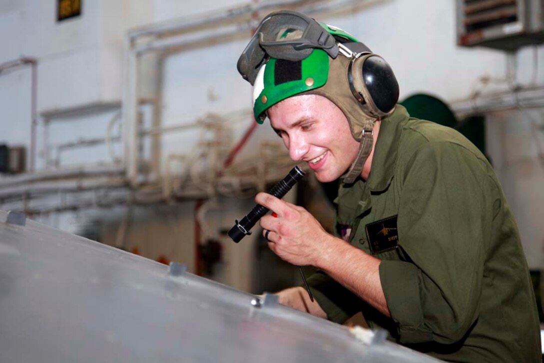 Corporal Nathan S. Sheppard, AV-8B harrier airframes mechanic, CH-53E Super Stallion mechanic, Marine Medium Helicopter Squadron 364 (Rein.), 15th Marine Expeditionary Unit, performs maintenance on a helicopter in the hangar bay of the USS Peleliu, Nov. 29. The 15th MEU is deployed as part of the Peleliu Amphibious Ready Group as a U.S. Central Command theater reserve force, providing support for maritime security operations and theater security cooperation efforts in the U.S. 5th Fleet area of responsibility. Sheppard, 23, is from Gillete, Wyo. (U.S. Marine Corps photo by Cpl. John Robbart III/Released)