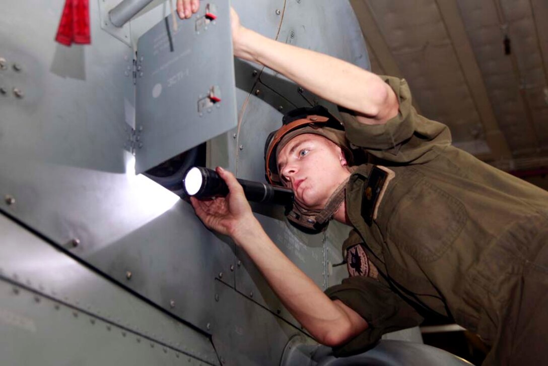 Lance Cpl. Matthew J. Lehman, H-1 mechanic, Marine Medium Helicopter Squadron 364 (Rein.), 15th Marine Expeditionary Unit, performs routine maintenance on an AH-1Z Super Cobra in the hangar bay of the USS Peleliu, Nov. 29. The 15th MEU is deployed as part of the Peleliu Amphibious Ready Group as a U.S. Central Command theater reserve force, providing support for maritime security operations and theater security cooperation efforts in the U.S. 5th Fleet area of responsibility. Lehman, 22, is from Tallmadge, Ohio. (U.S. Marine Corps photo by Cpl. John Robbart III/Released)