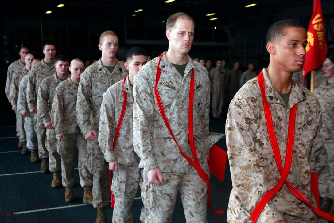 Marines and sailors with Marine Medium Helicopter Squadron 364 (Rein.), 15th Marine Expeditionary Unit, march to the rear of a formation after a squadron promotion and awards ceremony in the hangar bay of the USS Peleliu, Dec. 1. Marine Medium Helicopter Squadron 364 (Rein.) serves as the aviation combat element for the 15th MEU. The 15th MEU is deployed as part of the Peleliu Amphibious Ready Group as a U.S. Central Command theater reserve force, providing support for maritime security operations and theater security cooperation efforts in the U.S. 5th Fleet area of responsibility. (U.S. Marine Corps photo by Cpl. John Robbart III/Released)
