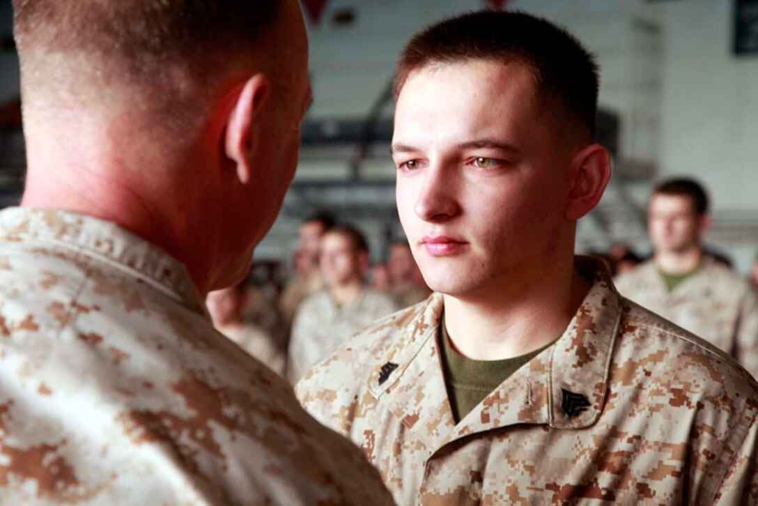 Newly promoted Sgt. Daniel J. Vance, administration non-commissioned officer-in-charge, 15th Marine Expeditionary Unit, stands at the position of attention after being promoted to his present rank, during the Command Element's promotion and awards ceremony in the hangar bay of the USS Peleliu, Dec. 1. The 15th MEU is deployed as part of the Peleliu Amphibious Ready Group as a U.S. Central Command theater reserve force, providing support for maritime security operations and theater security cooperation efforts in the U.S. 5th Fleet area of responsibility. Vance, 22, is from Sparta, Ky. (U.S. Marine Corps photo by Cpl. John Robbart III/Released)