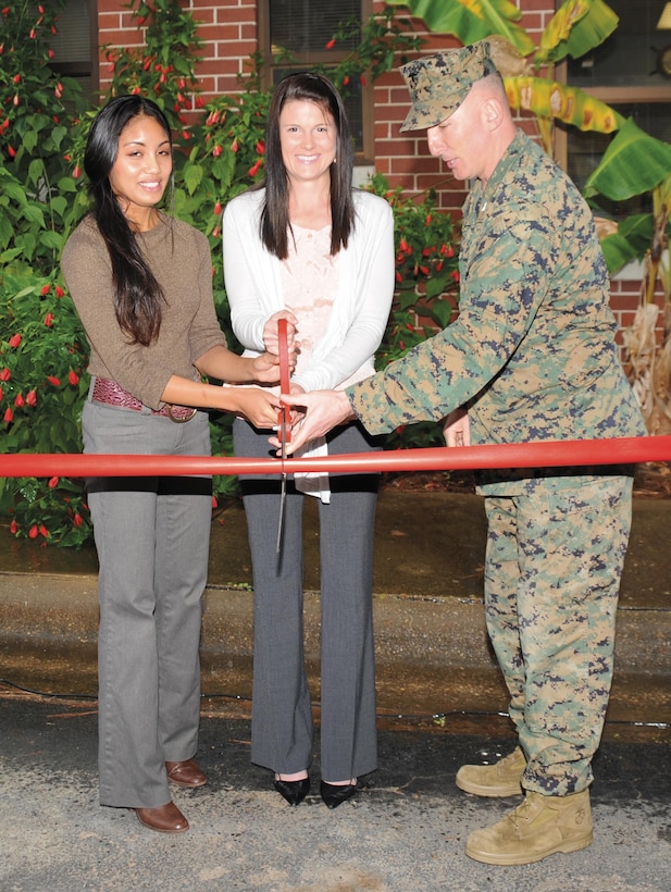 Col. Don Davis, commanding officer, Marine Corps Logistics Base Albany, and Heather Challet and Nikki Onuska, both volunteer caseworkers, Navy-Marine Corps Relief Society Albany, cut a large, red ribbon to symbolize the reopening.