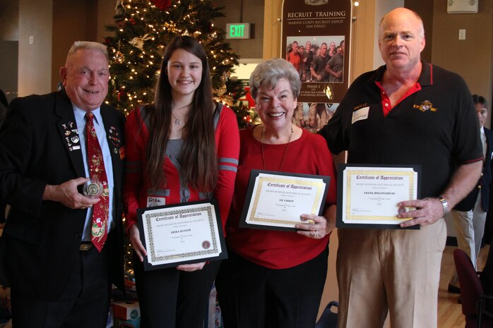 (Left to right) Retired Sgt. Major Bill Paxton, Erika Kruger, Lil Larken, and Frank Hollingshead hold up Volunteer of the Year awards and tokens of appreciation during the Tun Tavern Tea at the depot's Command Museum Dec. 1. The Tun Tavern Tea is an annual event and a social gathering of the members and supporters of the MCRD Historical Society. The event recognizes the work volunteers and supporters have done for the museum and society. This year's Tun Tavern Tea marked the 25th anniversary of the society and museum. They celebrated by recognizing the founding fathers and had displays throughout the museum showing history of the society and museum. 