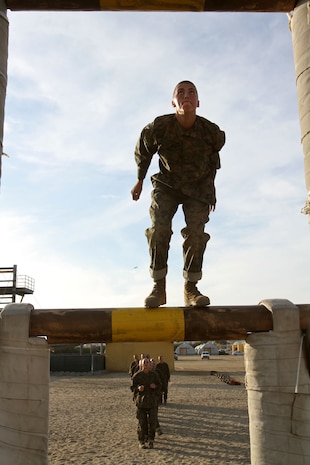 A Recruit of Company A, 1st Recruit Training Battalion, prepares to jump to the next log on an obstacle aboard Marine Corps Recruit Depot San Diego, Nov. 29. The obstacle is called the dirty deed and requires recruits jump onto the log and slide down.