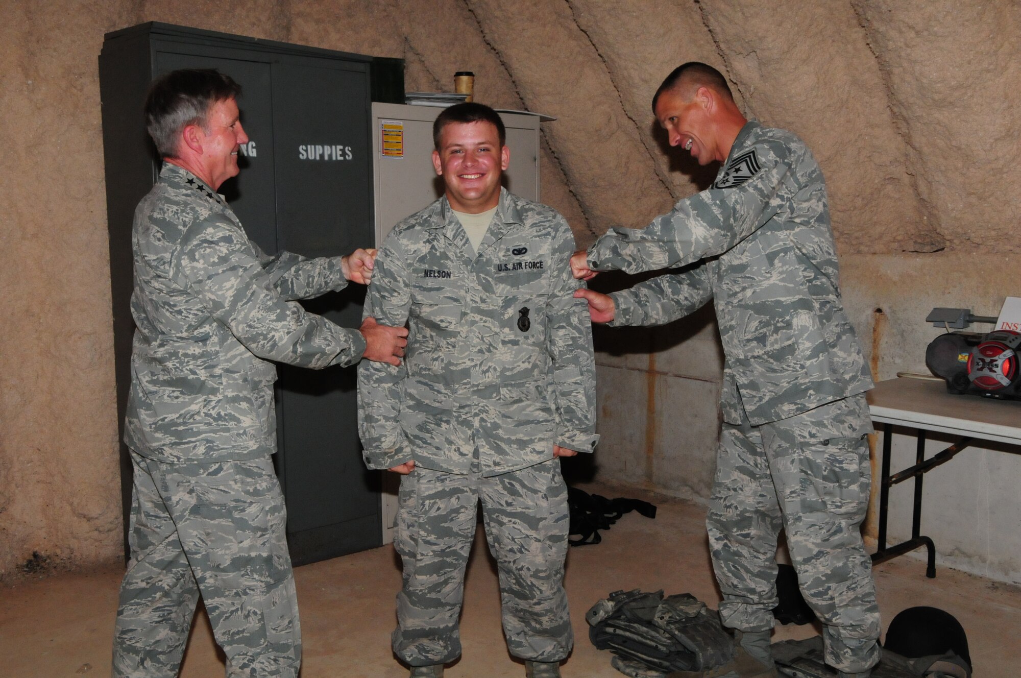 Gen. Herbert “Hawk” Carlisle, Pacific Air Forces commander, and Chief Master Sgt. Steve McDonald, PACAF command chief, pin stripes on recently promoted Staff Sgt. Benjamin Nelson, 736th Security Forces Squadron Pacific Regional Training Center instructor, at Northwest Field, Guam, Dec. 3, 2012. General Carlisle and Chief McDonald visited Team Andersen Airmen for the first time since they assumed their command roles. (U.S. Air Force photo by Airman 1st Class Marianique Santos/Released)