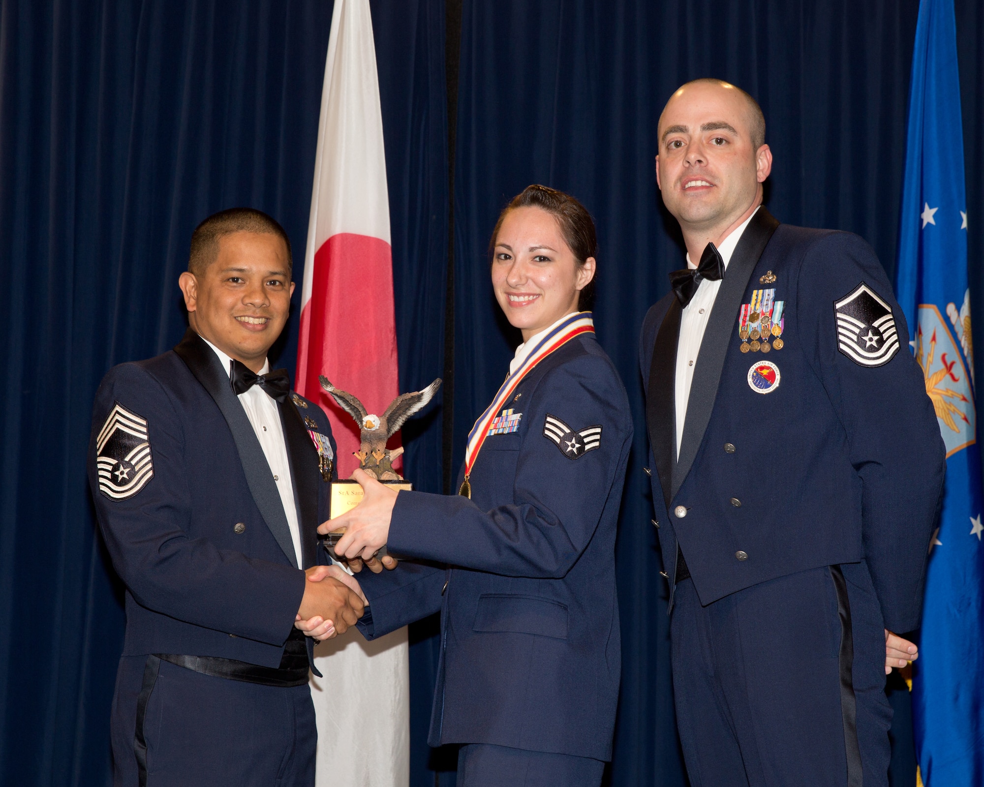 YOKOTA AIR BASE, Japan -- Senior Airman Sarah Blodgett (center), 374th Dental Squadron, is awarded the Commandant Award during the Airman Leadership School Class 13-A graduation ceremony at Yokota Air Base, Japan, Dec. 6, 2012. Chief Master Sgt. Rick Ramos (left), 515th Air Mobility Operations Group, and Master Sgt. Matthew Heifner (right), 374th Force Support Squadron, representatives of the Yokota's Chief's Group, presented the award to Blodgett during the ceremony. (U.S. Air Force photo by Osakabe Yasuo)  