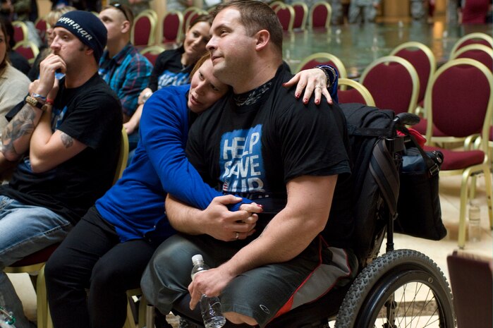 U.S. Army Sgt. Christopher Kurtz, 101st Airborne Division cavalry scout, and his wife Heather, embrace during the Wounded Warrior "Salute Our Troops" celebration Dec. 5, 2012, in Las Vegas. Wounded veterans were honored for their courageous service and bravery during the ceremony. (U.S. Air Force photo by Airman 1st Class Monet Villacorte)