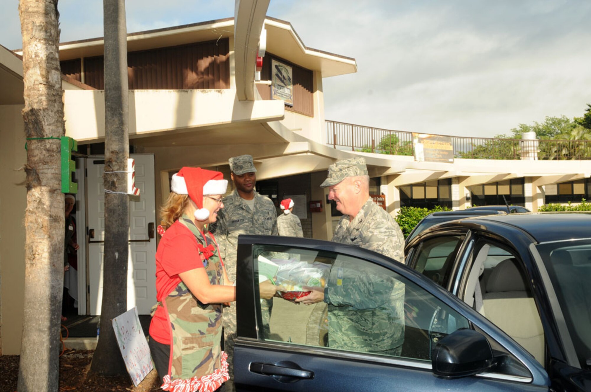 Col. Terry Scott, Vice Commander, 15th Wing, delivers cookies to
Angela Bennett, military spouse, for the 15th Wing Cookie Caper near the
Wright Brother's Cafe on Joint Base Pearl Harbor-Hickam, Hawaii, 4 Dec 2012.
The event is hosted by the 15th Operations Group, and cookie donations are
being collected to send to deployed Airmen this holiday season.  Photo by
David D. Underwood, Jr.