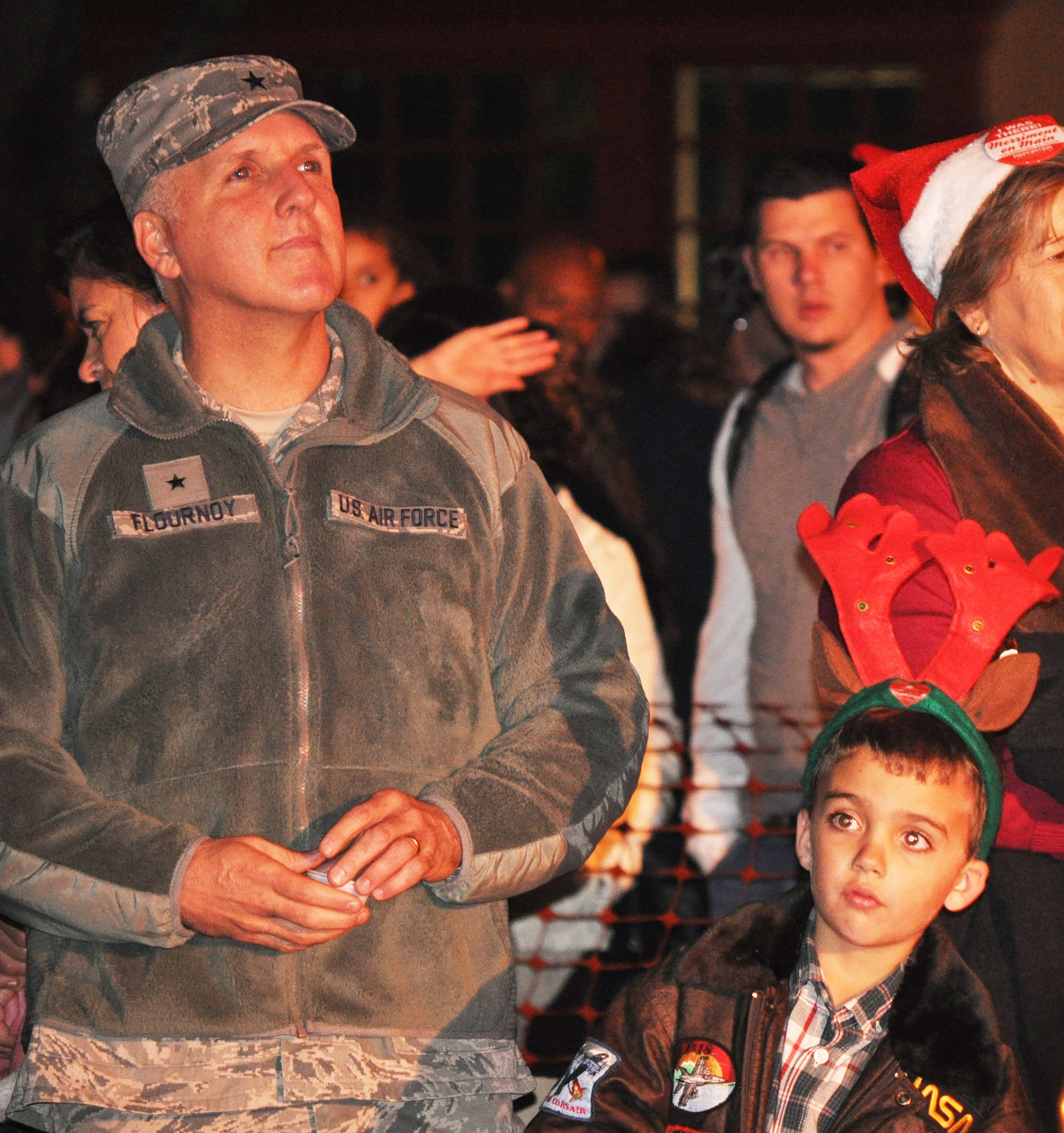 TRAVIS AIR FORCE BASE, Calif. -- Brig. Gen. Jay Flournoy and his son, Jack, watch one of the performances at the annual Vacaville Merriment on Main celebration Nov. 30. Flournoy and his partner commanders at Travis helped Mayor Steve Hardy flip the giant switch to light up the holiday tree downtown. Entertainment included Travis's Band of the Golden West, the Honeybee Trio, local musical acts, food, fun and, of course, Santa. (U.S. Air Force photo/Senior Master Sgt. Ellen Hatfield)