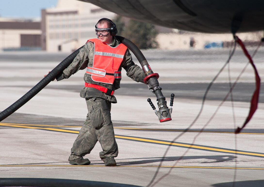 Airman 1st Class John McConnell, 28th Aircraft Maintenance Squadron, hauls a fuel line toward a B-1 bomber during a hot pit refueling activity at Ellsworth Air Force Base, S.D., Nov. 20, 2012. Hot pit refueling is a procedure, usually performed in a combat environment, that allows rapid refuel capabilities with two B-1 engines running and reduced maintenance turn time on the aircraft (U.S. Air Force photo by Airman 1st Class Alystria Maurer/Released)