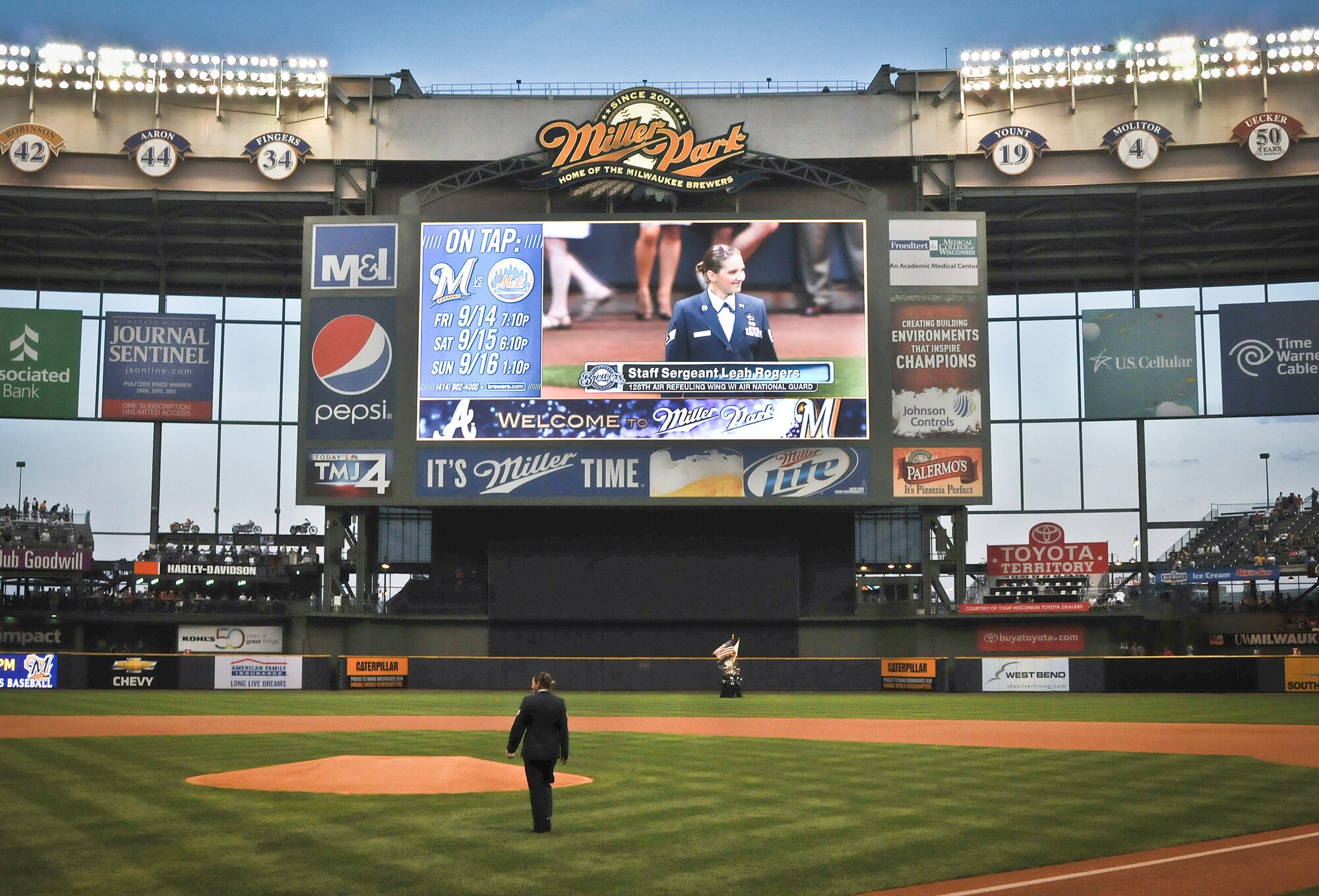 Rogers strides towards the pitcher’s mound at Miller Park in Milwaukee as her image is projected on the big screen Wed., Sept. 12, 2012. 
Rogers, a Financial Management Specialist at the 128th Air Refueling Wing, was selected to throw out the ceremonial first pitch in recognition of her recent deployment. (Air National Guard Photo by Staff Sgt. Jeremy M. Wilson / Released)
