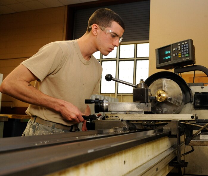 Airman 1st Class Cameron Arruda, 2nd Maintenance Squadron Fabrication Flight journeyman, grinds a brass bushing on Barksdale Air Force Base, La., Dec. 6. Bushings are attached to the pin that connects the fuel tanks to the aircraft to prevent friction from metal rubbing together and damaging the aircraft. (U.S. Air Force photo/Airman 1st Class Andrew Moua)