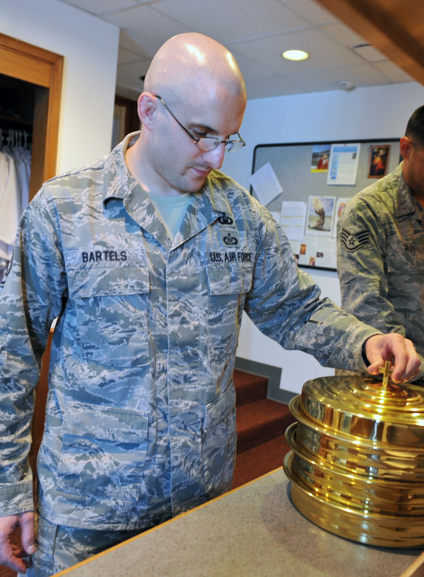 Staff Sgt. Lukas Bartels, 509th Bomb Wing chaplain assistant, prepares for communion prior to at Protestant worship service at the Whiteman AFB Chapel. Bartels returned from his six-month deployment to Al Dhafra Air Base in United Arab Emirates, July 12, where he performed Sunday services, weekly set-ups and unit visitations. (U.S. Air Force photo/Heidi Hunt)