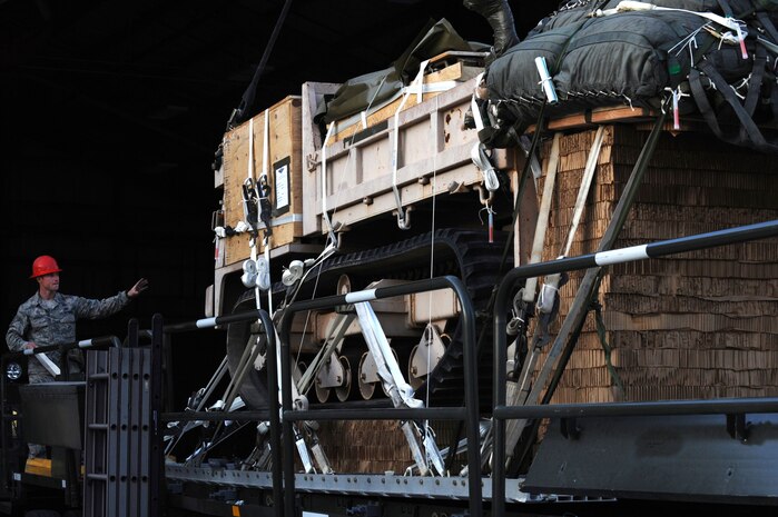 Tech. Sgt. Jason Bischoff, 820th RED HORSE Squadron airborne pavement and equipment operator, directs the crane operator to pick up a track dump from a Tunner 60K aircraft loader Nov. 29, 2012, at Nellis Air Force Base, Nev. Airborne and Air Assault-qualified RED HORSE Airmen have specialized equipment and vehicles to provide expedient airfield or facility assessment and repairs. (U.S. Air Force photo by Staff Sgt. William P. Coleman)