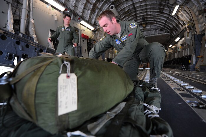 U.S. Air Force Staff Sgts. Matthew Gaffney, 57th Weapons Squadron loadmaster from Joint Base McGuire-Dix-Lakehurst, N.J., and Norman Metz, 3rd Operations Support Squadron loadmaster from Elmendorf Air Force Base, Ala., inspect the extraction chute attached to heavy construction equipment on a C-17 Globemaster III Nov. 29, 2012, at Nellis Air Force Base, Nev. The C-17 is capable of rapid strategic delivery of troops and all types of cargo to main operating bases or directly to forward bases in deployed areas. (U.S. Air Force photo by Staff Sgt. William P. Coleman)
