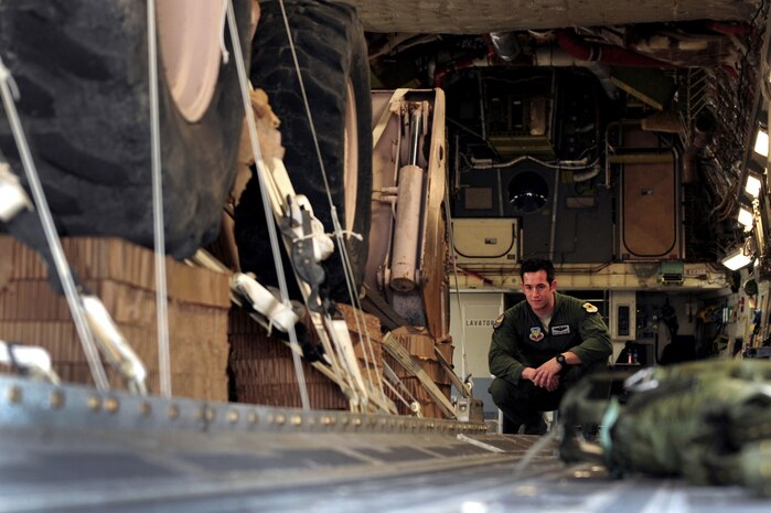 U.S. Air Force Staff Sgt. Matthew Gaffney, 57th Weapons Squadron loadmaster from Joint Base McGuire-Dix-Lakehurst, N.J., monitors construction equipment as it is loaded into a C-17 Globemaster III Nov. 29, 2012, at Nellis Air Force Base, Nev. The maximum payload capacity of the C-17 is 170,900 pounds and its maximum gross takeoff weight is 585,000 pounds. (U.S. Air Force photo by Staff Sgt. William P. Coleman)