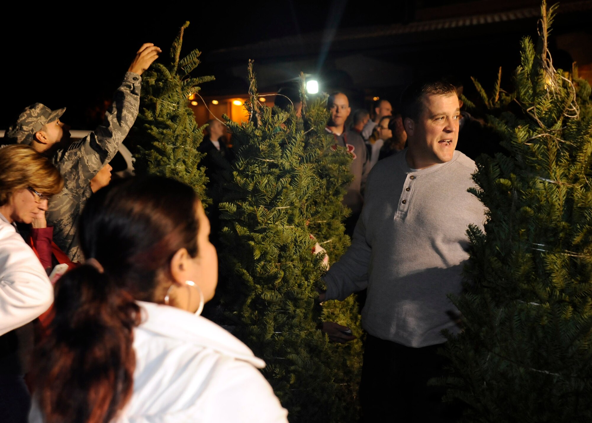 LOMPOC, Calif. – Vandenberg military members and civilians gather around trees during the 6th annual Trees for Troops event at Santa Barbara Bank and Trust’s Lompoc branch here Wednesday evening, Dec. 5, 2012. The event included a buffet table with hot and cold foods, speeches and tree pick-ups for deployed spouses and families in need assigned to the base. (U.S. Air Force photo/Michael Peterson)