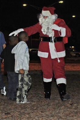 Santa Claus greets children as he arrives at the annual base tree lighting ceremony on Seymour Johnson Air Force Base, N.C., Dec. 3, 2012. After the base tree was lit, children were able to sit on Santa’s lap to tell him what they wanted for Christmas. (U.S. Air Force photo/Airman 1st Class John Nieves Camacho/Released)
