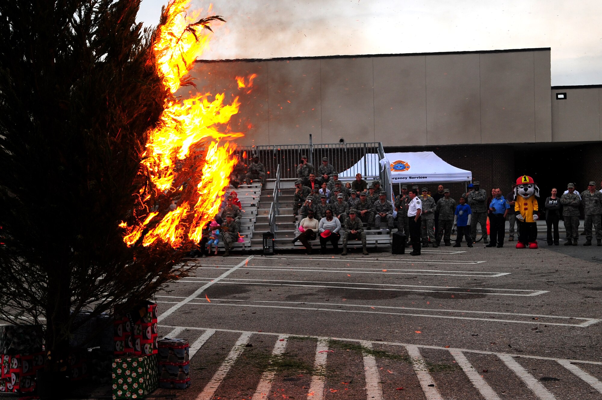 An audience watches as a tree burns at the Exchange on Seymour Johnson Air Force Base, N.C., Dec. 5, 2012. Every year, U.S. fire departments respond to roughly 240 fires during the holiday season and one out of every 18 fires result in a death. (U.S. Air Force photo/Airman 1st Class Mariah Tolbert/Released)