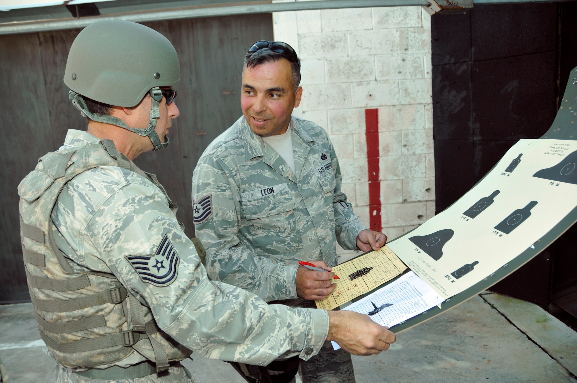 Tech. Sgt. Robert Gibson (left), 70th Aerial Port Squadron air transportation specialist, receives instruction while reviewing his M-4 carbine practice targets with Tech. Sgt. Leon Martin, 482nd Security Forces Squadron Combat Arms Training and Maintenance instructor, at Homestead Air Reserve Base’s CATM range, Dec. 1. Airmen are scheduled to qualify within the 90 days prior to a deployment or annually, depending on their job, to stay within Air Force regulations. During an evaluation for the M-4, Airmen must hit the target on 17 of 24 rounds to qualify. All told, Airmen fire 192 rounds, to include both practice and evaluation rounds. (U.S. Air Force photo/Senior Airman Jacob Jimenez)