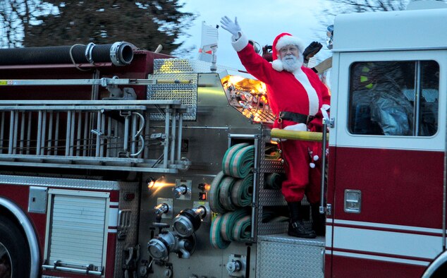 Santa Claus arrives at the base tree lighting ceremony on the 92nd Civil Engineer Squadron fire department engine seven at Fairchild Air Force Base, Wash., Dec. 3, 2012. Members of Fairchild gather to officially start the holiday season by watching the tree lighting ceremony at the base chapel. (U.S. Air Force photo by Airman 1st Class Taylor Curry)
