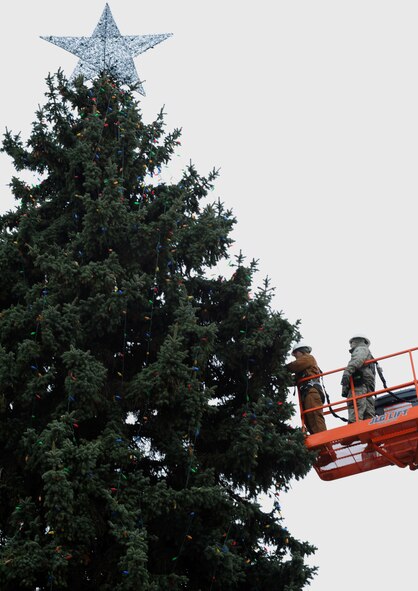 Senior Airmen Travis Barfield and Jason Ardans place lights on a tree in front of the base chapel Nov. 28, 2012, in preparation for the annual wing tree lighting ceremony at Fairchild Air Force Base, Wash. Barfield and Ardans are 92nd Civil Engineer Squadron electricians. (U.S. Air Force photo by Senior Airman Dennis Ayres)