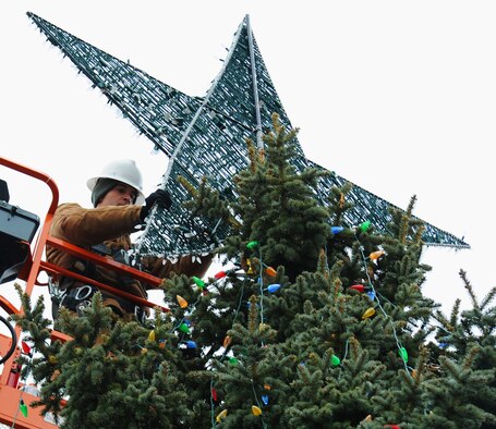 Senior Airman Travis Barfield adjusts the star on a tree in front of the base chapel Nov. 28, 2012, in preparation for the annual wing tree lighting ceremony at Fairchild Air Force Base, Wash. Barfield is a 92nd Civil Engineer Squadron electrician. (U.S. Air Force photo by Senior Airman Dennis Ayres)