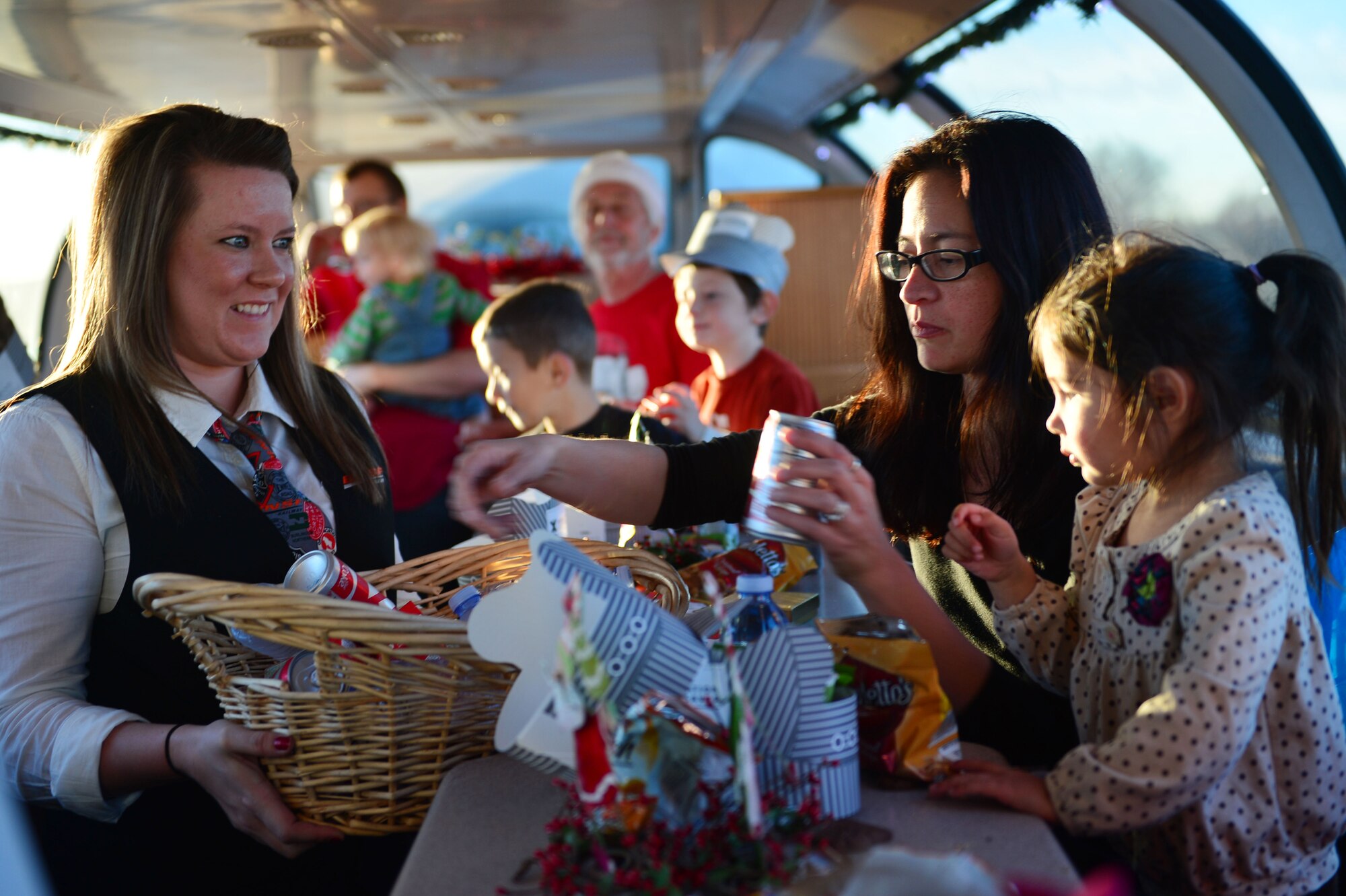 A staff member serves a military family with seasonal treats and beverages during a ride on the Holiday Express in Clovis, N.M., Dec. 3, 2012. The BNSF Holiday Express train expects to provide rides to more than 3,000 members of military families during its 13-day trip through Texas, Oklahoma, New Mexico, and Arizona. (U.S. Air Force photo/Airman 1st Class Eboni Reece)