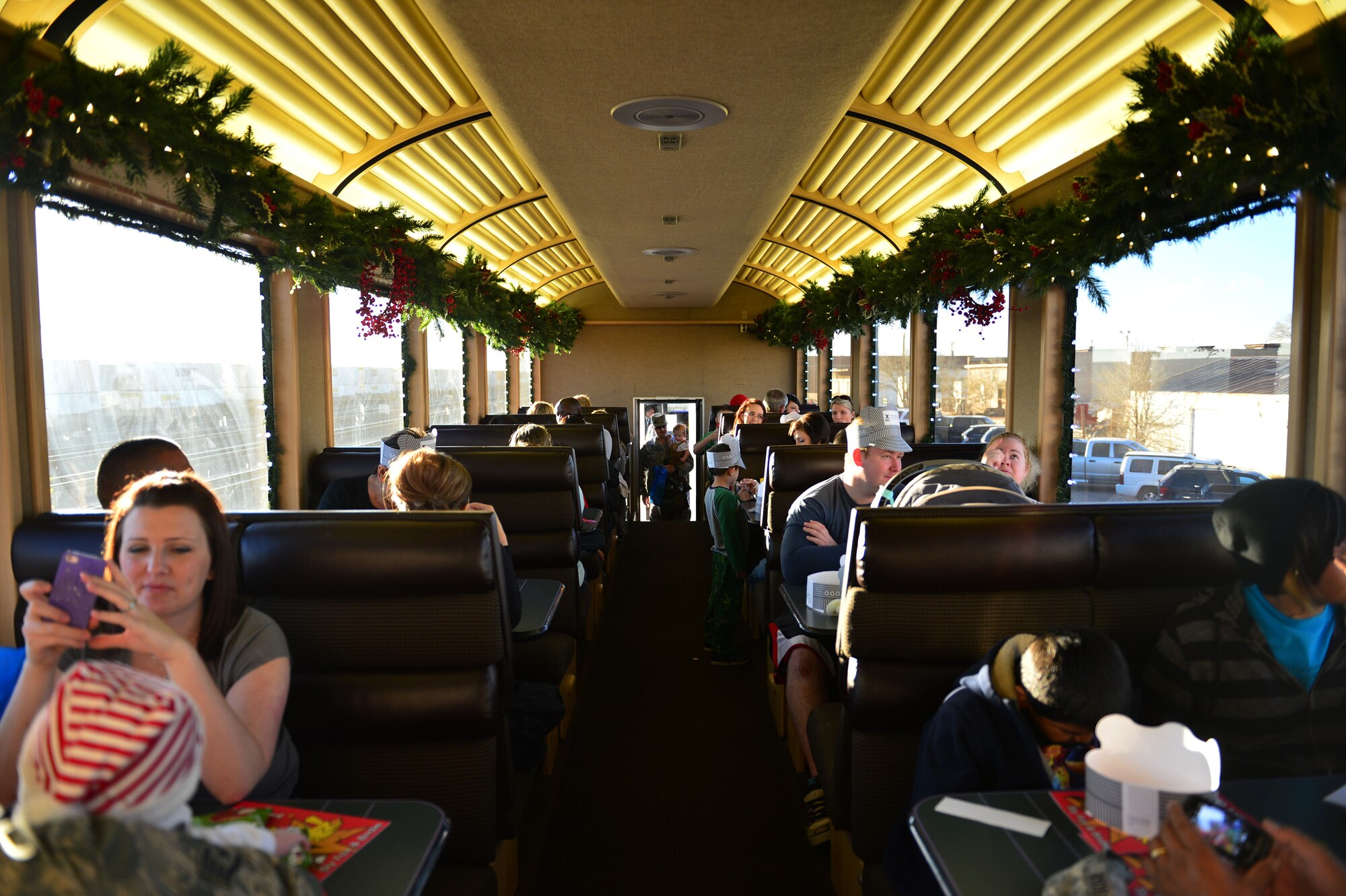 Military members and their loved ones ride on a vintage passenger car of the Holiday Express in Clovis, N.M., Dec. 3, 2012. The BNSF Holiday Express train expects to provide rides to more than 3,000 members of military families during its 13-day trip through Texas, Oklahoma, New Mexico, and Arizona. (U.S. Air Force photo/Airman 1st Class Eboni Reece)