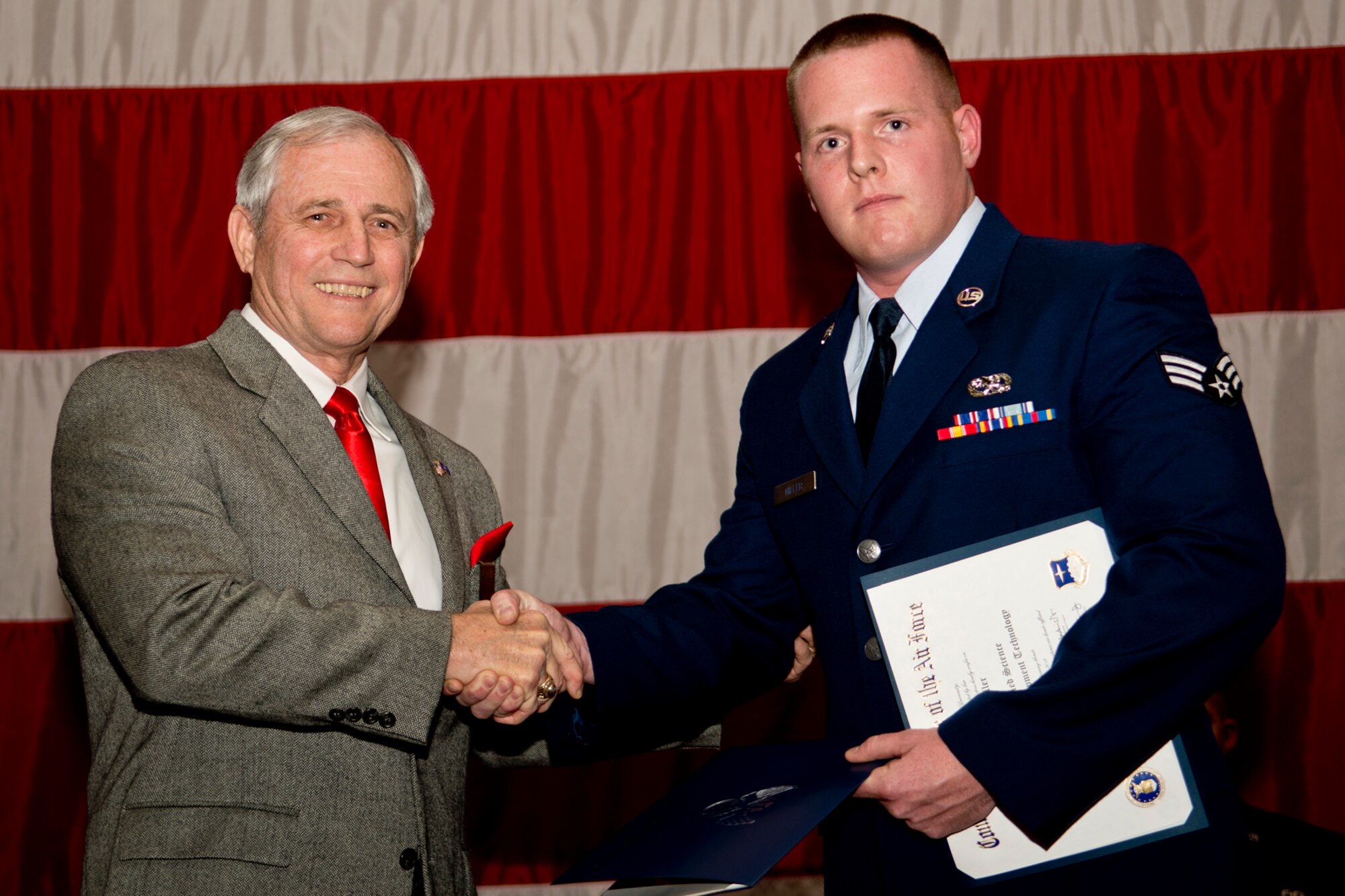 Retired Chief Master Sgt. Jack Skaggs presents the Pitzenbarger Award to Senior Airman Chad Miller during a 207th Bomb Wing Commander's Call, Dec. 2, 2012, Barksdale Air Force Base, La. The award is given to deserving Airmen for outstanding academic achievement in the Community College of the Air Force. (U.S. Air Force photo by Master Sgt. Greg Steele/Released)