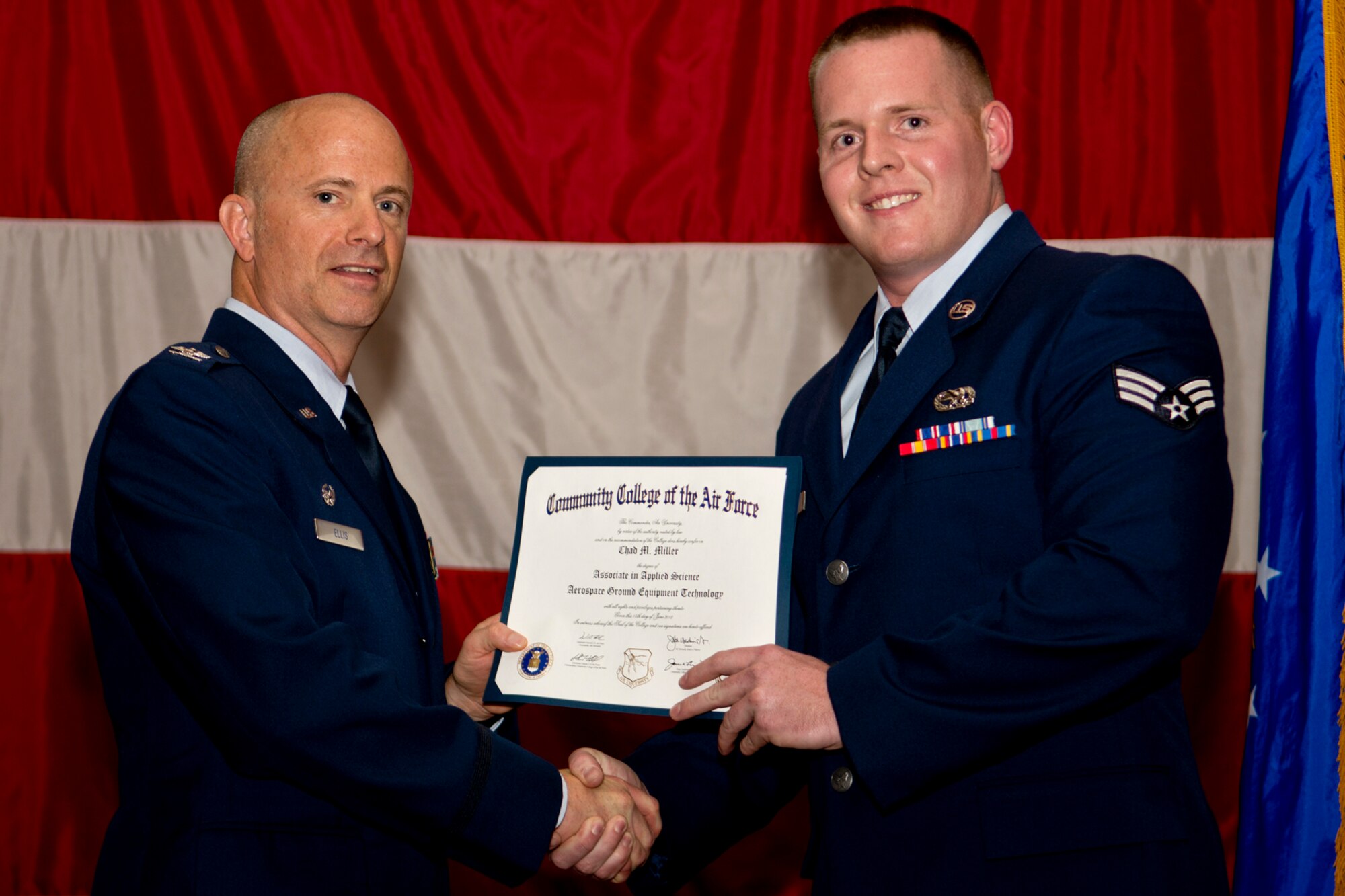 U.S. Air Force Col. Jonathan Ellis, 307th Bomb Wing commander, presents a Community College of the Air Force certificate to Senior Airman Chad Miller, Dec. 2, 2012, Barksdale Air Force Base, La. Miller completed an Associates Degree in Aerospace Ground Equipment Technology. (U.S. Air Force photo by Master Sgt. Greg Steele/Released)