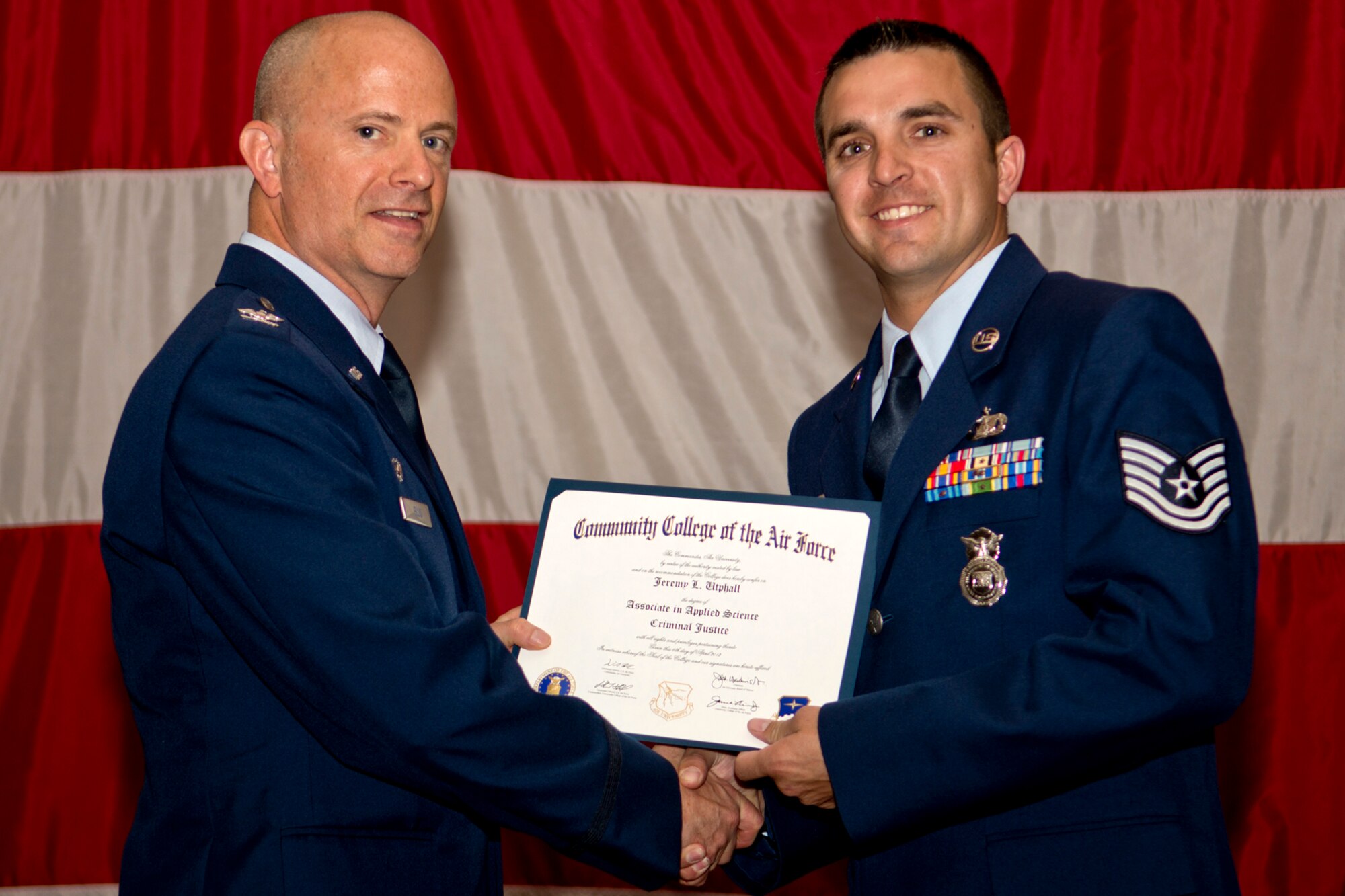 U.S. Air Force Col. Jonathan Ellis, 307th Bomb Wing commander, presents a Community College of the Air Force certificate to Tech. Sgt. Jeremy Utphall, Dec. 2, 2012, Barksdale Air Force Base, La. Utphall completed an Associates Degree in Criminal Justice. (U.S. Air Force photo by Master Sgt. Greg Steele/Released)