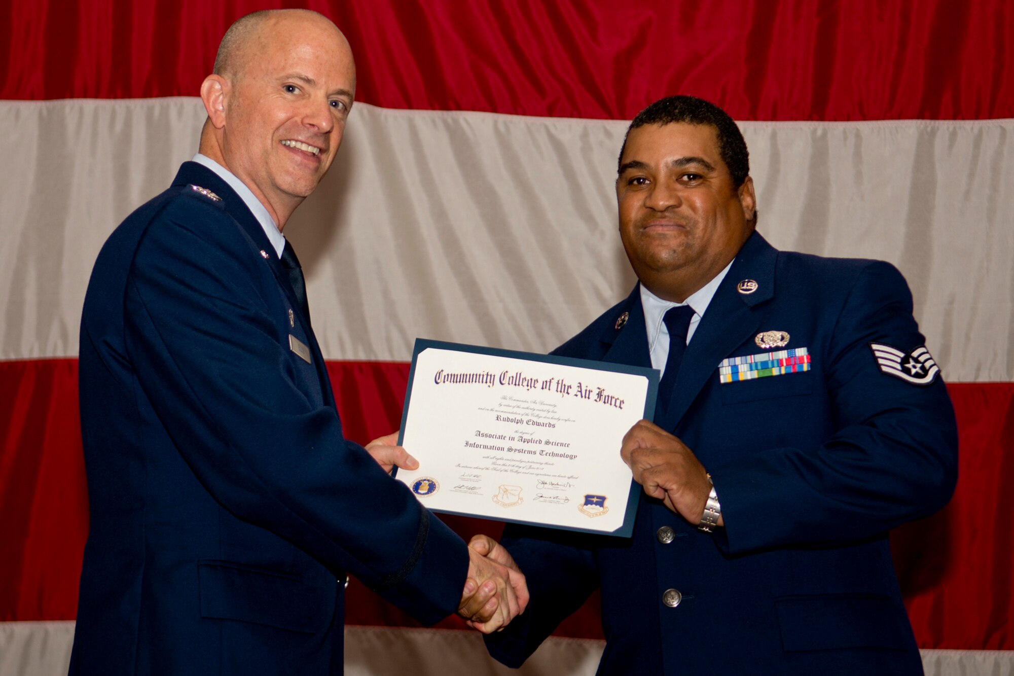 U.S. Air Force Col. Jonathan Ellis, 307th Bomb Wing commander, presents a Community College of the Air Force certificate to Staff Sgt. Rudolph Edwards, Dec. 2, 2012, Barksdale Air Force Base, La. Edwards completed an Associates Degree in Information Systems Technology. (U.S. Air Force photo by Master Sgt. Greg Steele/Released)