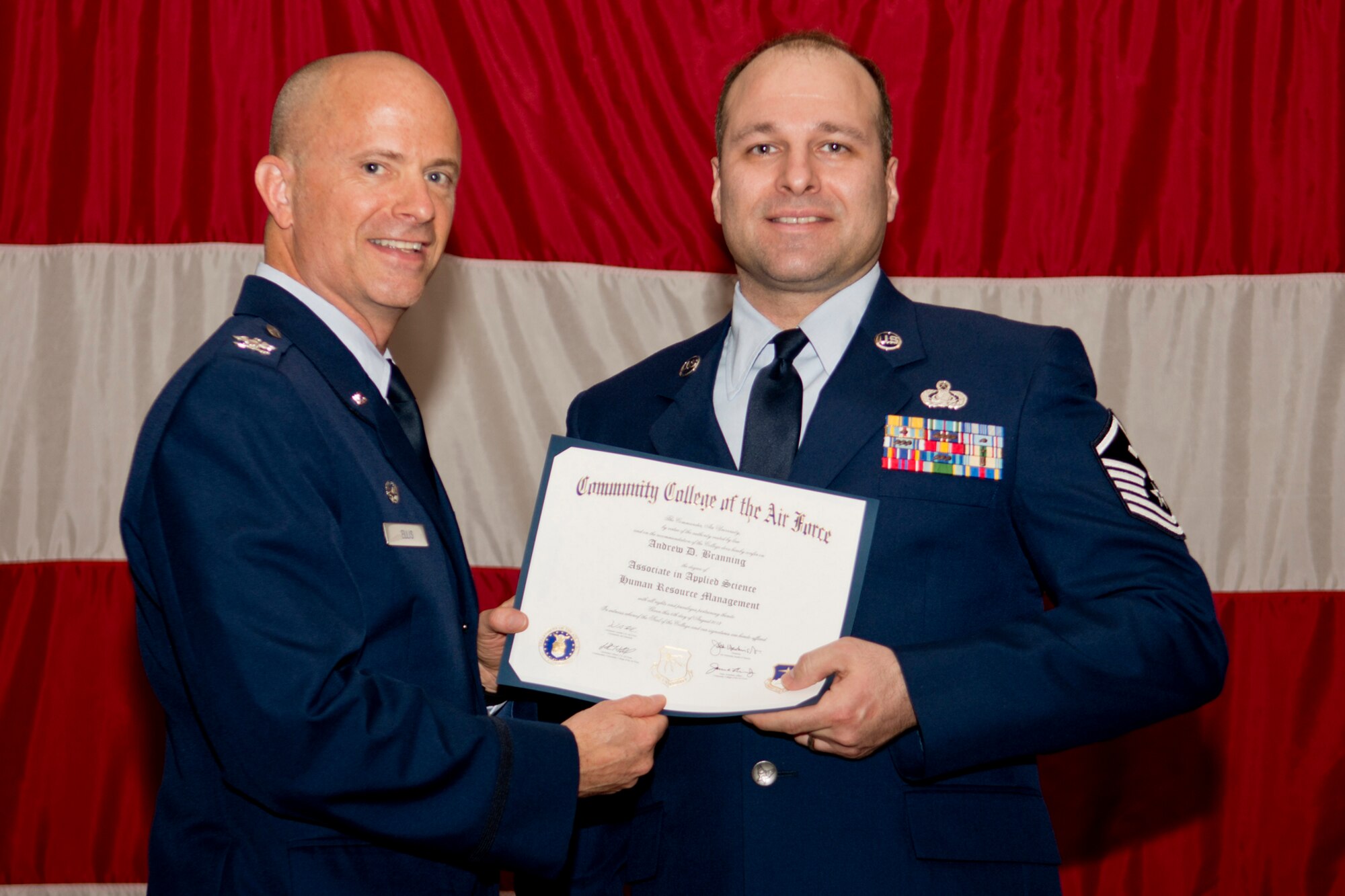U.S. Air Force Col. Jonathan Ellis, 307th Bomb Wing commander, presents a Community College of the Air Force certificate to Master Sgt. Andrew Branning, Dec. 2, 2012, Barksdale Air Force Base, La. Branning completed an Associates Degree in Human Resource Management. (U.S. Air Force photo by Master Sgt. Greg Steele/Released)