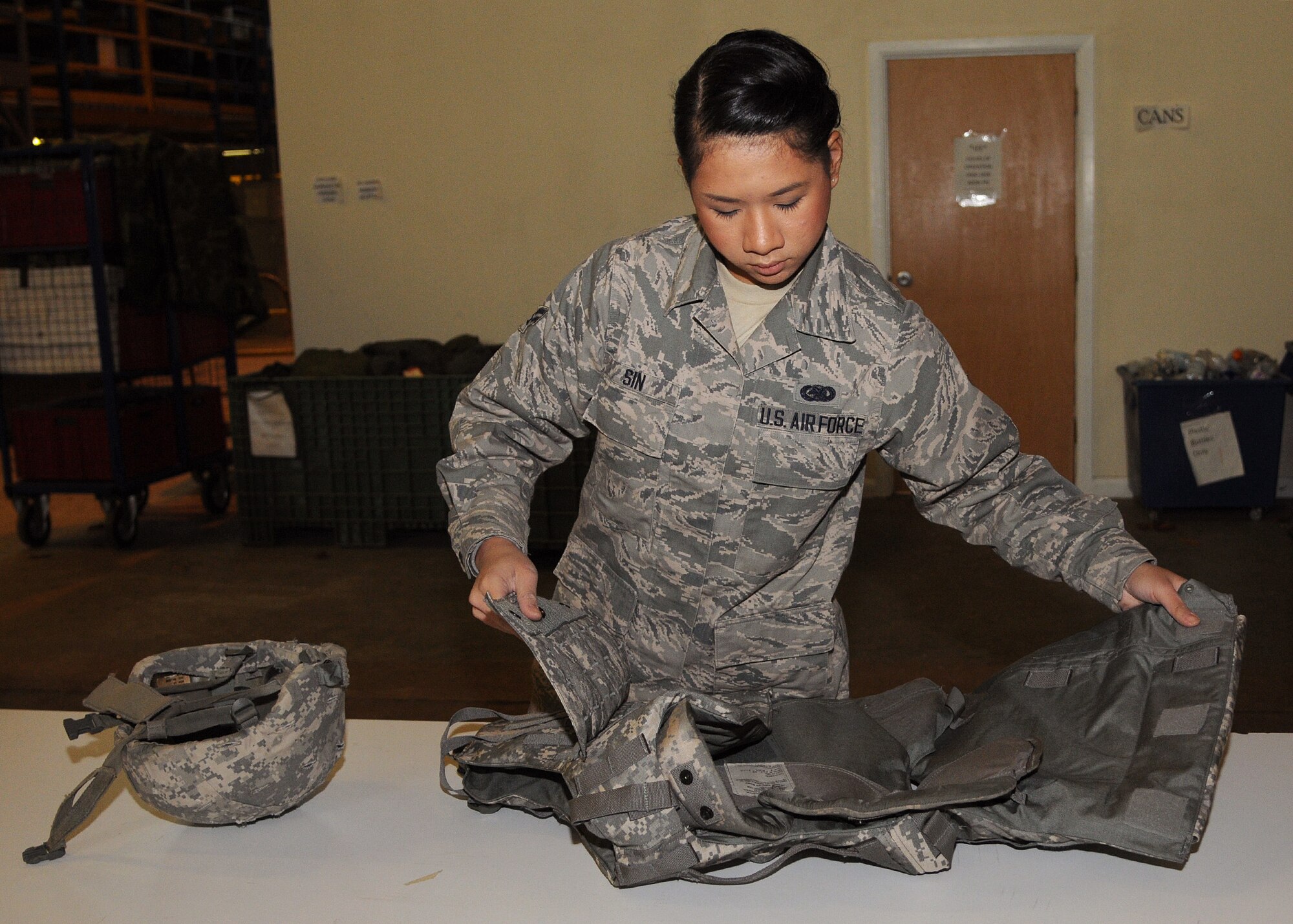 Airman 1st Class Nita Sin, 100th Logistics Readiness Squadron individual protective equipment apprentice from Philadelphia, Pa., prepares a protective vest Dec. 6, 2012, in building 550 at RAF Mildenhall, England. The 100th LRS issues protective equipment to deploying service members and civilians. (U.S. Air Force photo by Airman 1st Class Kelsey A. L. Waters/Released) 