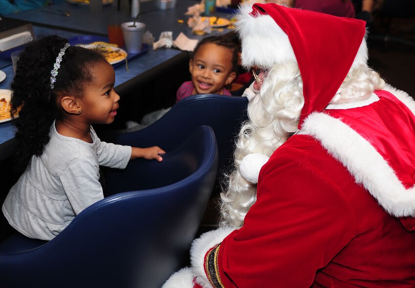 Santa Claus greets children during the Hearts Apart deployed spouse dinner at Cannon Air Force Base, N.M., Dec. 4, 2012. The dinner was part of the Hearts Apart program which offers spouses of deployed, temporary duty assignment, or remote tour military members a chance to relax and connect with other families going through the same experience. (U.S. Air Force photo/Airman 1st Class Ericka Engblom)