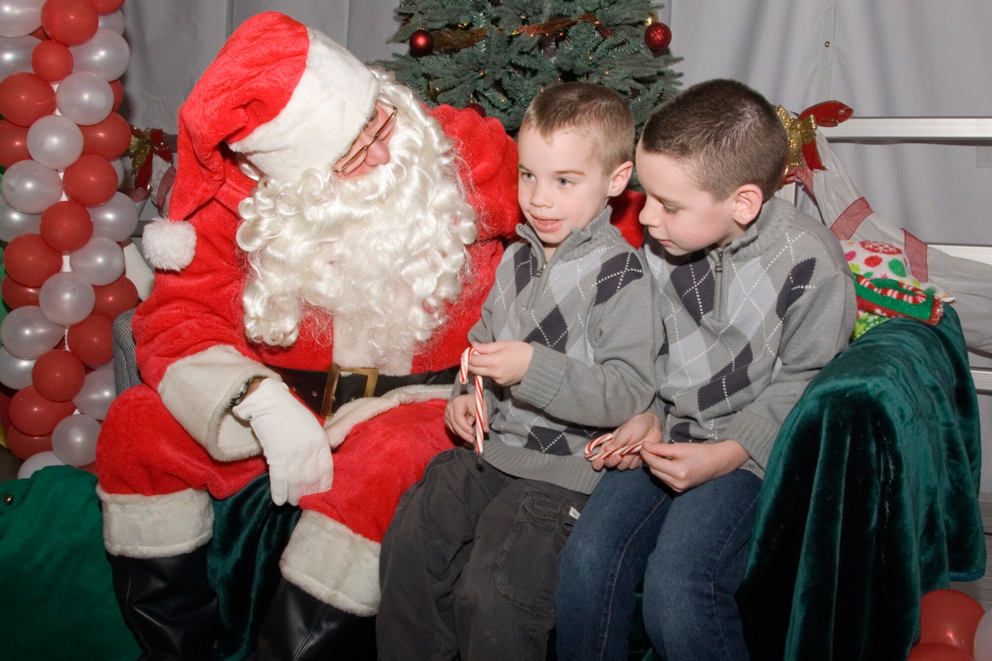 GRISSOM AIR RESERVE BASE, Ind.-- Brothers Jake and Josh Buckley sit near Santa Clause to request their holiday wishes during the base Christmas party here Dec. 1.  Throughout the fun filled evening Airmen and their families enjoyed a variety of activities including: cookie decorating, reindeer prancing, gingerbread house making and present wrapping contests. In addition, there was dancing and drawings for prizes. (U.S. Air Force photo/Staff Sgt. Ben Mota)