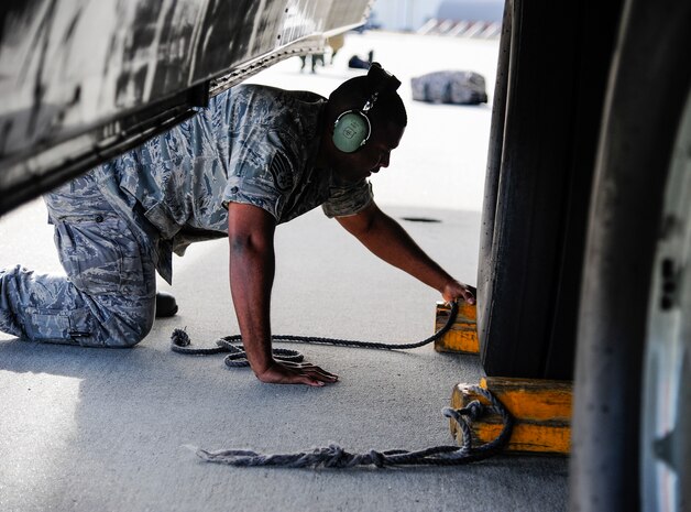 Staff Sgt. Norris Lewis, 437th Aircraft Maintenance Squadron crew chief, places wheel chocks under a C-17 Globemaster III Dec. 5, 2012, at Joint Base Charleston - Air Base, S.C . 437th AXMS uses wheel chocks to prevent accidental movement and used for additional safety to just setting the brakes. (U.S. Air Force photo/Staff Sgt. Rasheen Douglsa)