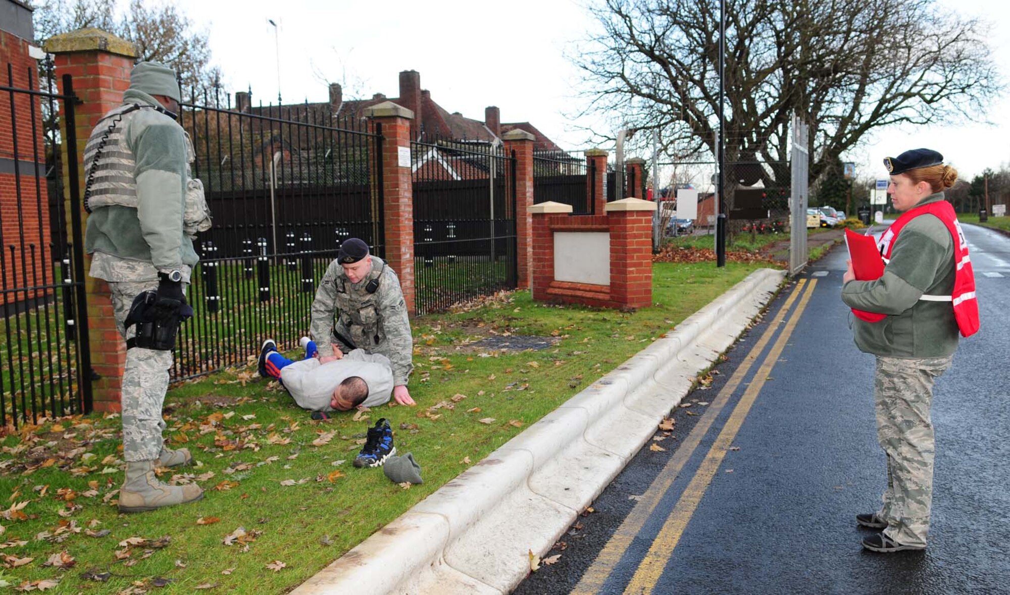 From left, Staff Sgt. Michael Denton, 100th Security Forces Squadron combined controller, and Airman 1st Class Bradley Pruzzo, 100th SFS response force member, hold down a handcuffed suspect as they search him after he illegally entered the base Dec. 4, 2012, during an operational readiness exercise at RAF Mildenhall, England. During the exercise scenario, ingspector general augmentees evaluated Denton, from Newark, N.J.; Pruzzo, from Detroit, Mich., and other 100th SFS members. The ORE is one of many exercises in preparation for a combined unit inspection in 2013. (U.S. Air Force photo by Karen Abeyasekere/Released)
