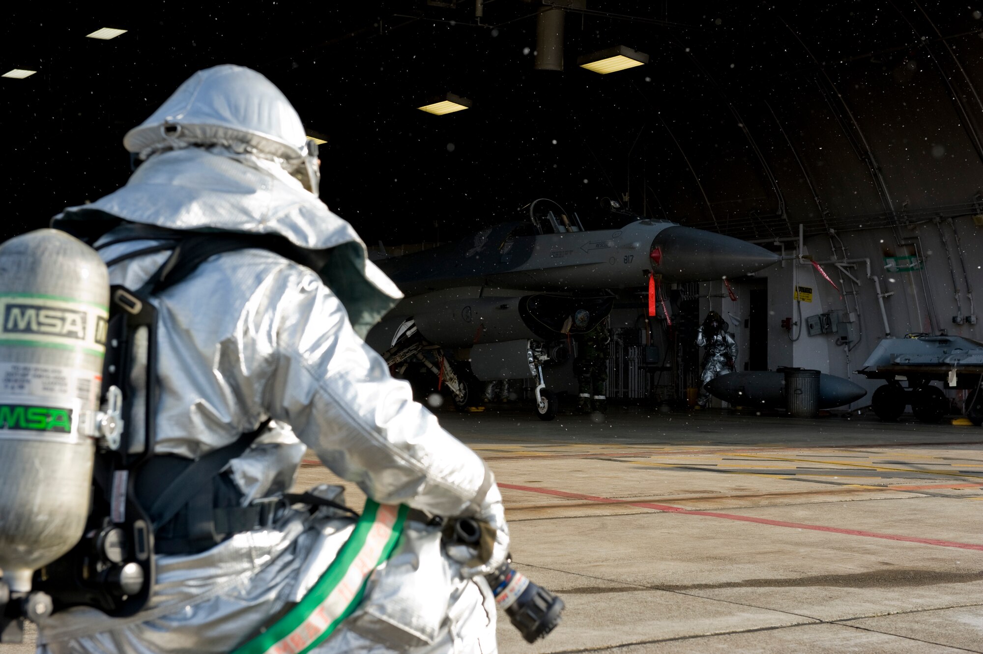 A 35th Civil Engineer Squadron firefighter waits for Harden Aircraft Shelter doors to slide open before entering a rescue training scenario, Dec. 5, 2012, during an Operational Readiness Exercise at Misawa Air Base, Japan. Firefighters responded to a pilot egress scenario with two Aircraft Rescue Fire Fighting vehicles, which are designed specifically to tackle aircraft and airfield fires. (U.S. Air Force by Staff Sgt. Jess Lockoski)