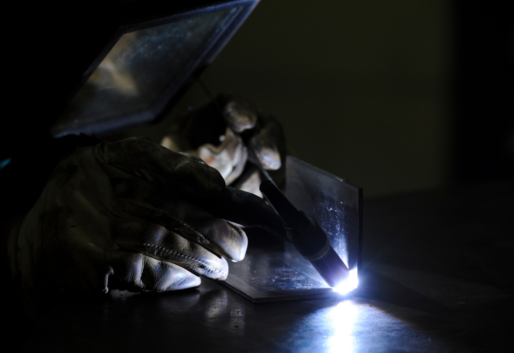 U.S. Air Force Col. Brian McDaniel, 18th Wing vice commander, welds two pieces of stainless steel together during his visit to the 18th Equipment Maintenance Squadron on Kadena Air Base, Japan, Dec. 6, 2012. Welding is a fabrication or sculptural process that joins materials, usually metals or thermoplastics, by causing coalescence. This is often done by melting the materials and adding a filler to form a pool of molten material that cools to become a strong joint. Pressure is sometimes used in conjunction with heat to produce the weld. (U.S. Air Force photo/Airman 1st Class Justin Veazie)