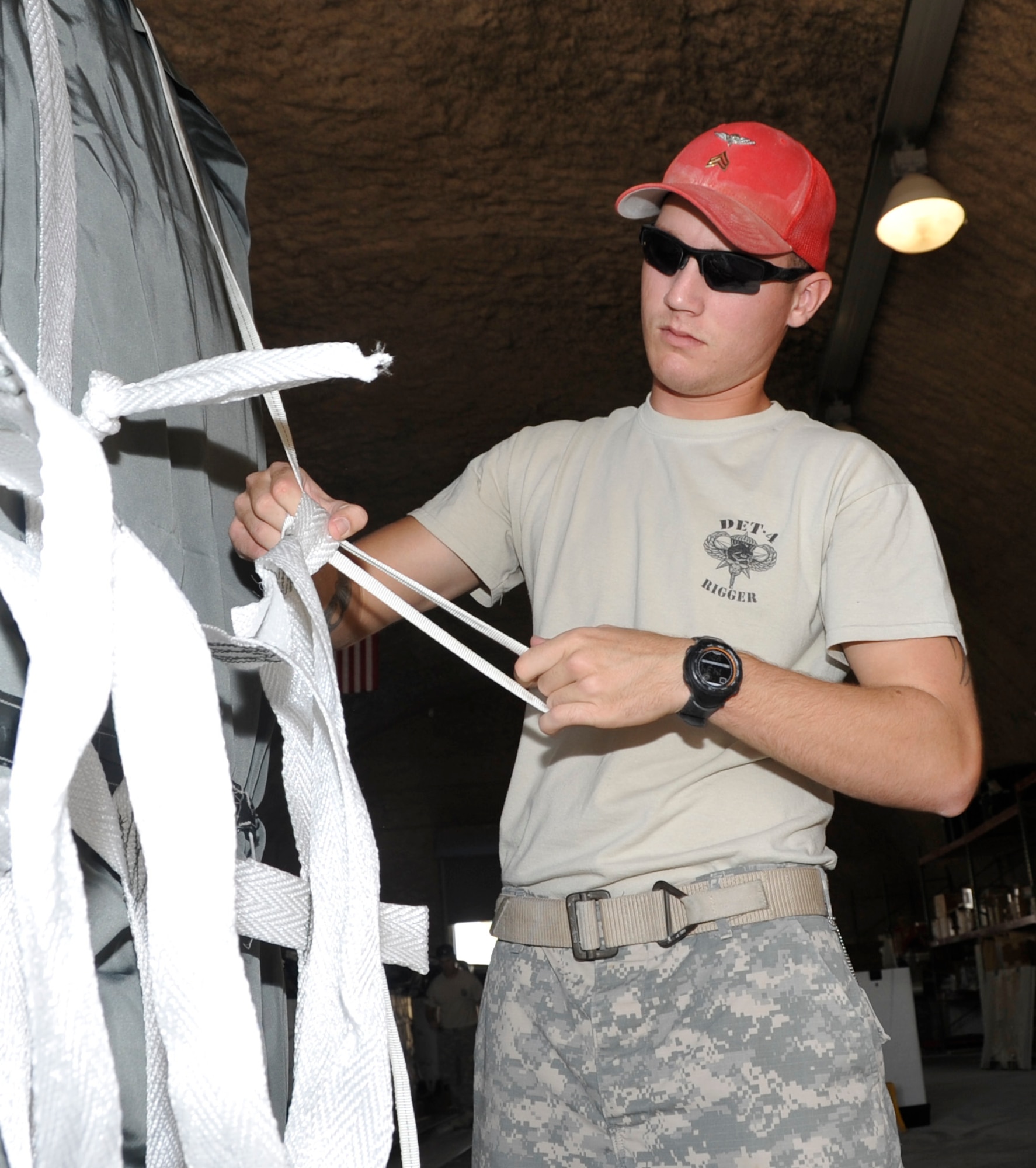 SOUTHWEST ASIA - Army Sgt. Jack Arnold, 421st Quartermaster Company Detachment 4 shop foreman, secures the low-cost, low-altitude airdrop cargo sling Dec. 4. The detachment’s mission is to create and build airdrop loads to resupply ground troops in Afghanistan. The 24-man team rigs and drops bundles mainly containing food, water, fuel, building materials and wood. On average, the detachment constructs approximately 670 bundles a month. Arnold, a native of Warner Robins, Ga., is deployed from Fort Valley, Ga. (U.S. Air Force photo/Senior Airman Bryan Swink)