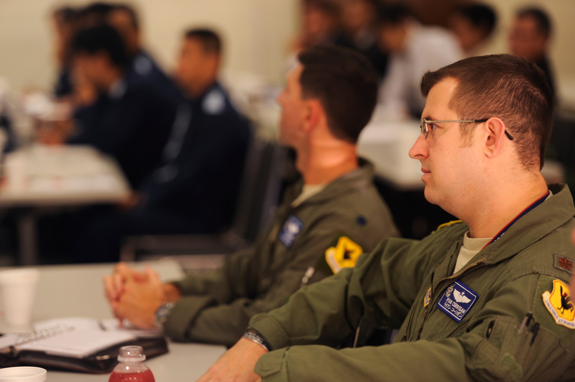 U.S. Air Force Maj. Ryan Corrigan, 18th Wing Flight Safety chief, listens to opening remarks during the joint table-top exercise at the Schilling Community Center on Kadena Air Base, Japan, Dec. 4, 2012. Each of the U.S. military branches partner with members from Okinawan government agencies and emergency services for the periodic exercise to ensure the two countries work well together in the event of a U.S. military aircraft incident in the local community. The event was the eighth exercise based on a similar scenario between the U.S. military and Okinawan officials. (U.S. Air Force photo/Senior Airman Maeson L. Elleman/released)